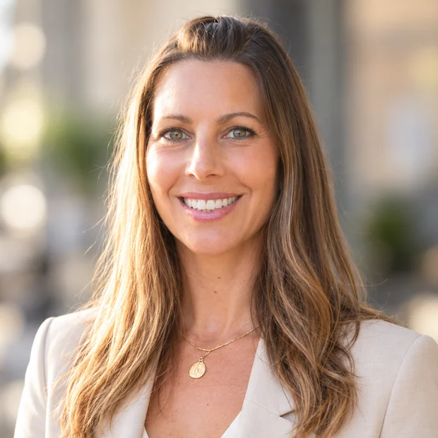 Mélanie Scaturro smiling in a cream tailored blazer